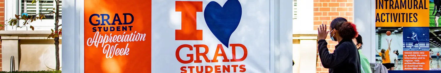 Students walking by Graduate Student Appreciation Week banner
